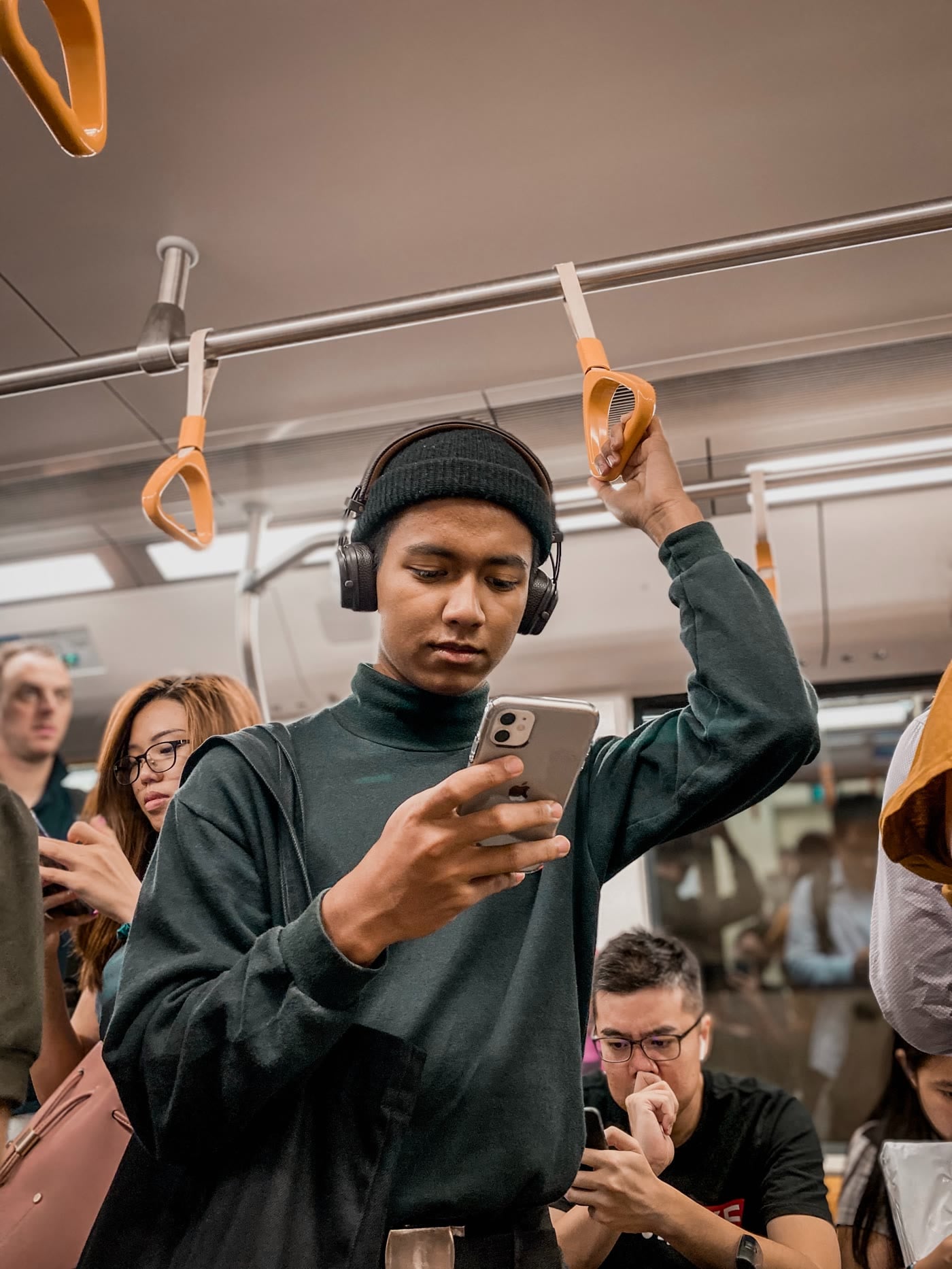 Man som läser i mobilen på bussen